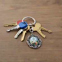 Load image into Gallery viewer, Our Lady of Fatima Oval Keychain with Floral Silver Tone Frame
